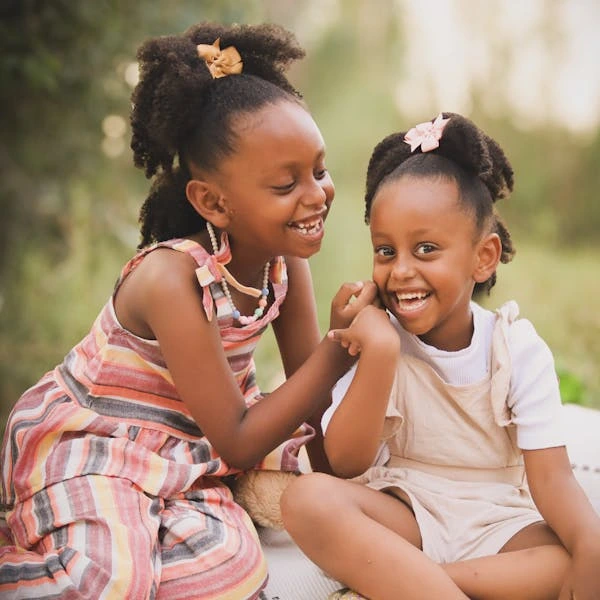 Joyful Sisters Laughing in a Park Setting